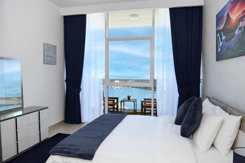 a bedroom with a bed and a large window at Live close to Lagoons Canal - 1 BR Apartment in Ras al Khaimah