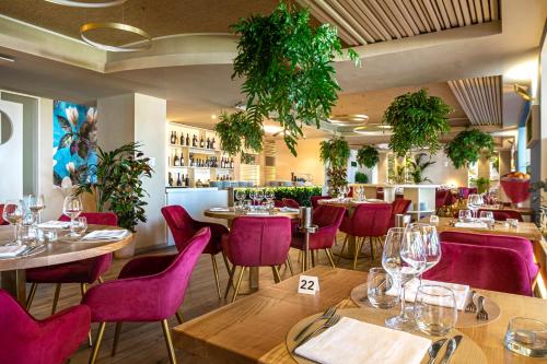 ein Restaurant mit Holztischen und lila Stühlen in der Unterkunft Sentido Michelizia Tropea Resort in Tropea