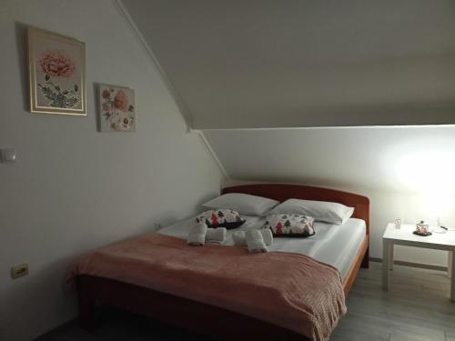 a bedroom with a bed with two stuffed animals on it at Apartman Mina 1 in Vrdnik