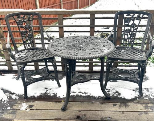 two chairs and a table in the snow at Lovely Single Room in Hither Green