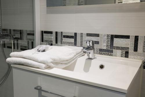 y baño con lavabo y toallas. en Résidence Victoria Surf, en Biarritz