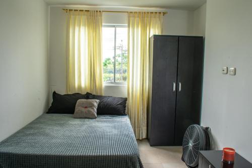 a bedroom with a bed and a large window at casa privada cerritos pereira in Pereira