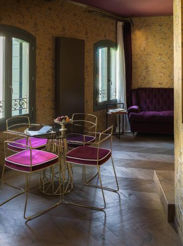 a dining room with purple chairs and a table at Madama Garden Retreat in Venice