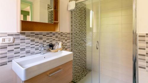een badkamer met een wastafel en een douche bij Appartamento Carmi con giardino in Siracusa
