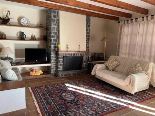 sala de estar con sofá y chimenea en Cal Cuaresma en Isona