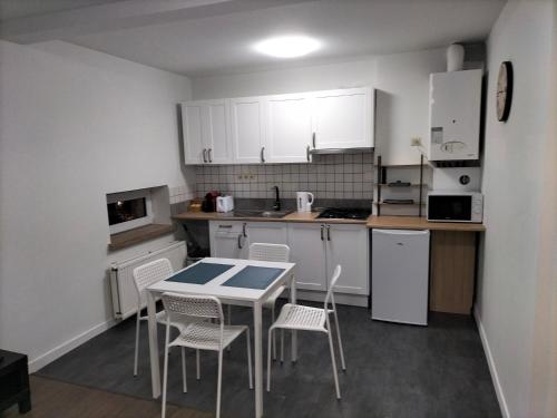 a kitchen with white cabinets and a table and chairs at Super central in Brussels in Brussels