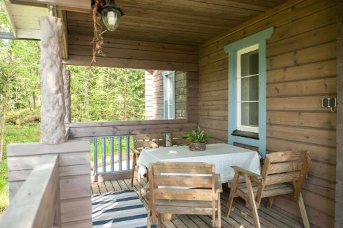 - une table et des chaises sur la terrasse couverte d'une cabine dans l'établissement Sinikallio | Paajoen Vuokramökit, à Himos