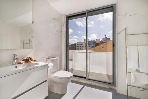 een witte badkamer met een toilet en een raam bij Succeed Campo Pequeno Apartments in Lissabon