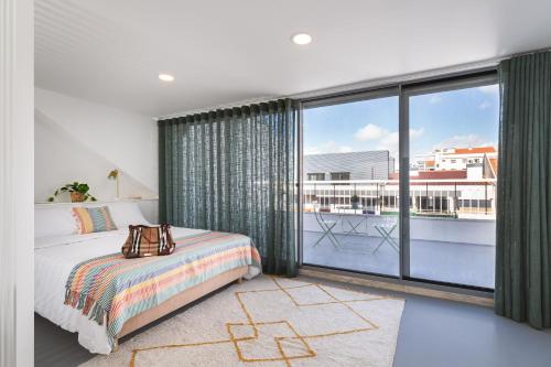 a bedroom with a bed and a large window at Succeed Campo Pequeno Apartments in Lisbon