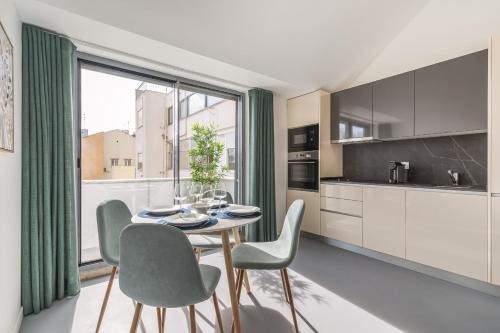a kitchen and dining room with a table and chairs at Succeed Campo Pequeno Apartments in Lisbon