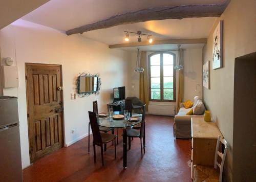 a living room with a table and a dining room at Le Logis des Cascades 2 in Moustiers-Sainte-Marie