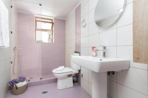 a white bathroom with a sink and a toilet at Villa Astoria Keri in Keri