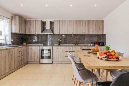 a kitchen with a table with a bowl of fruit on it at Villa Astoria Keri in Keri