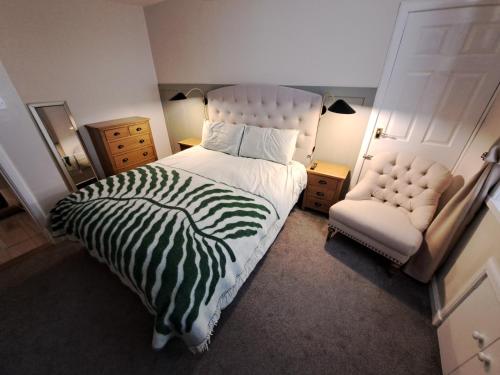 a bedroom with a large bed and a chair at Church view in Wick