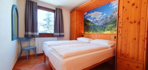 una camera con due letti e una grande finestra di Residence Bait da Mott a Livigno