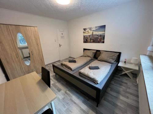 een kleine slaapkamer met een bed en een tafel bij Schönes einfaches Zimmer in Oldenburg 109 in Oldenburg