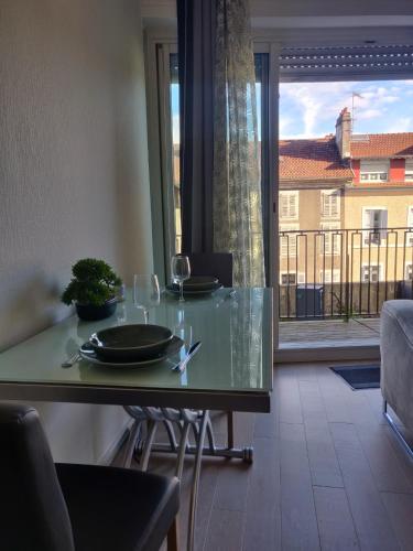 une table à manger avec des verres et une vue sur un balcon dans l'établissement Le Palais -Idéal Couple- Terrasse Hypercentre, à Pau