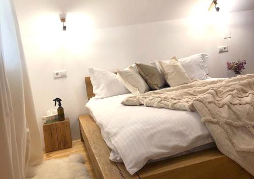a bedroom with a large bed with white sheets and pillows at Cabana Wonderland in Păuliş