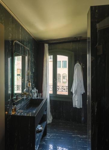 a black bathroom with a sink and a window at Madama Garden Retreat in Venice
