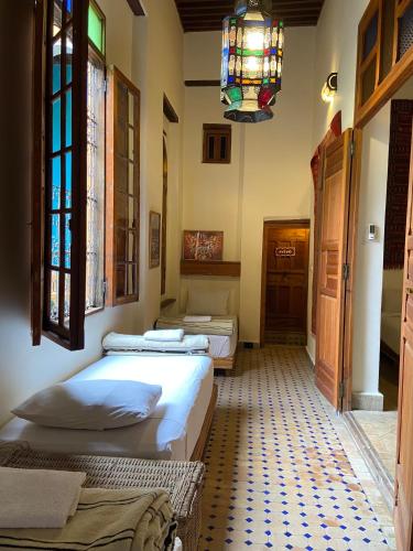 a room with three beds and a chandelier at Medina social club in Fès