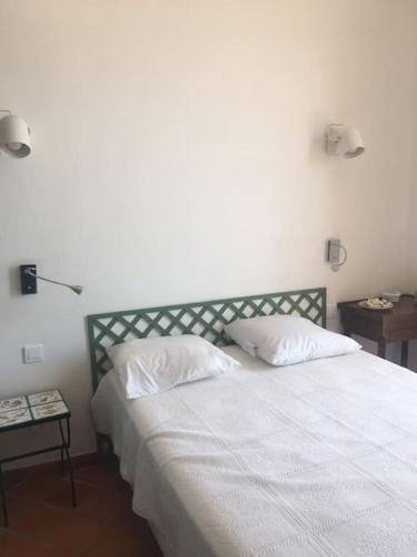 une chambre avec un lit blanc avec deux oreillers dans l'établissement L’Aiguade, appartement d'exception à Cassis, à Cassis
