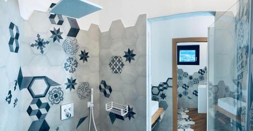 La salle de bains est revêtue de carrelage bleu et blanc. dans l'établissement SUITE&BREAKFAST Cà Rossa, à Sondrio