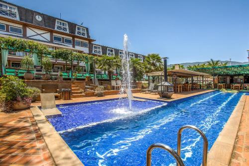 una piscina con una fuente en el medio de un edificio en Hotel Villa Lobos Spa Romantik en Extrema