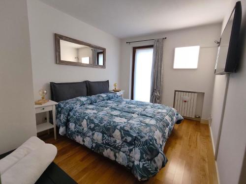 una camera da letto con un letto con un piumone blu e una finestra di L'Ultima Rosa a Verona