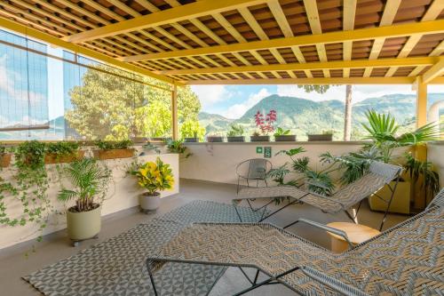 un balcón con sillas, plantas y montañas en el fondo en Hotel Plantación en Jardín