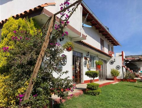 a white house with flowers in the yard at Villa Sofia in Tlatlauquitepec