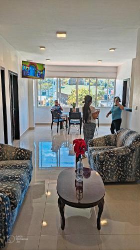 a living room with couches and a table at Suite Familiar en Puerto Ayora in Puerto Ayora