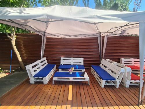 a deck with two chairs and a white umbrella at Alojamiento Quincho Pascual in Las Compuertas