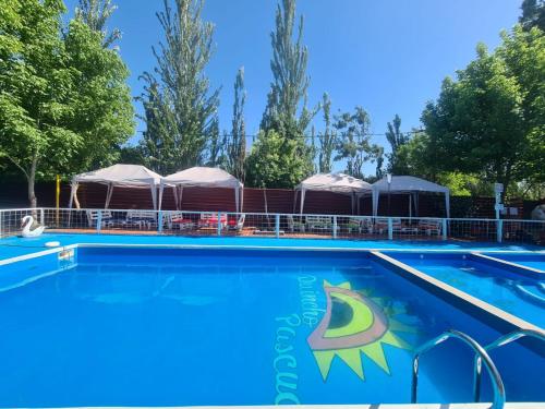 a swimming pool at a resort with umbrellas at Alojamiento Quincho Pascual in Las Compuertas
