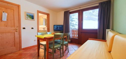 a room with a table and chairs and a window at Residence Bait da Mott in Livigno