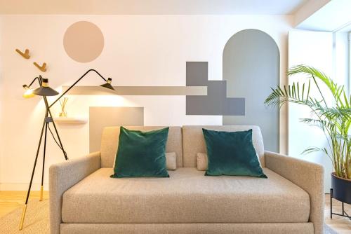 a living room with a couch with two green pillows at Ando Living - Douradores House in Lisbon