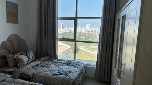 1 dormitorio con cama y ventana grande en 2 bedrooms new brand with amazing view, en Ajman