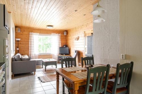 een eetkamer en een woonkamer met een tafel en stoelen bij Kujanpää | Paajoen Vuokramökit in Himos