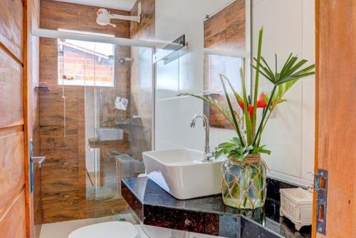 a bathroom with a sink and a glass shower at Pousada Canto de Zul in Itacaré