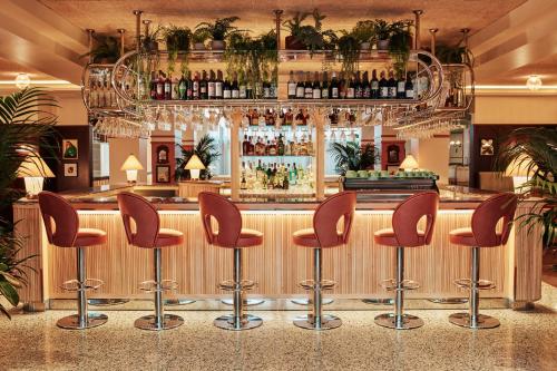 a bar with brown stools in a restaurant at The Hoxton, Shepherds Bush in London