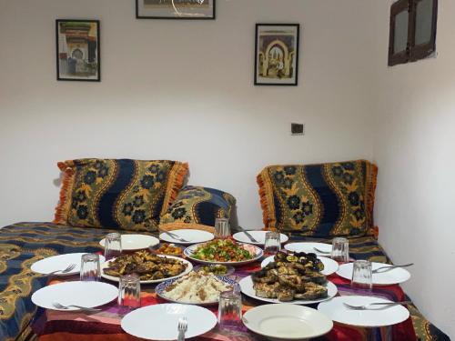 a table with plates of food on it at Emallayan Hostel in Imsouane