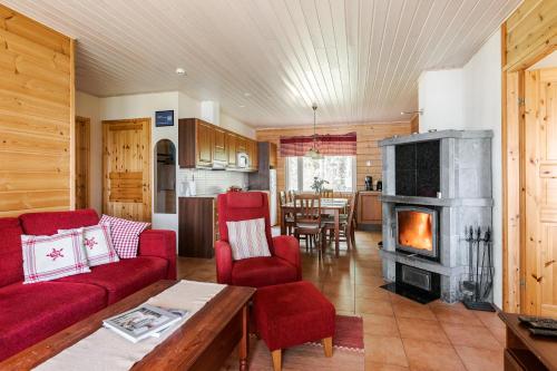 uma sala de estar com mobiliário vermelho e uma lareira em Suvituuli | Paajoen Vuokramökit em Himos
