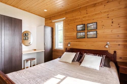 um quarto com uma cama numa parede de madeira em Suvituuli | Paajoen Vuokramökit em Himos