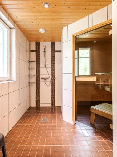 ein Badezimmer mit Dusche und Sitzbank in einem Zimmer in der Unterkunft Suvituuli | Paajoen Vuokramökit in Himos