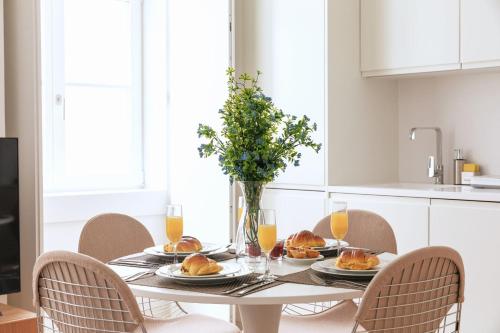 a dining room table with plates of food and orange juice at Ando Living - Douradores House in Lisbon