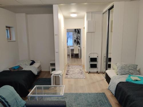 salon z 2 łóżkami i szklanym stołem w obiekcie M Apartments Rahola w mieście Tampere