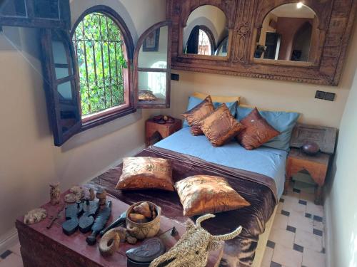 Ryad Nour Al Janoub في مراكش: غرفة نوم عليها سرير ومخدات