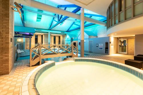 uma grande piscina num edifício com tectos azuis em Gloucester Robinswood Hotel, BW Signature Collection em Gloucester