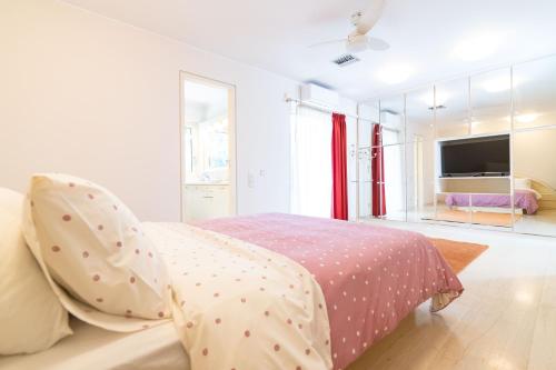 a white bedroom with a bed with polka dots at Sunlight House - Palatial Fully Equipped Apartment Near The Sea in Athens