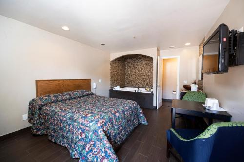 een hotelkamer met een bed en een wastafel bij Post Road Inn Motel in Avenel