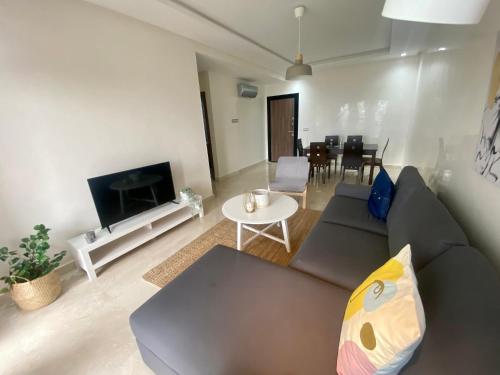 ein Wohnzimmer mit einem Sofa und einem Tisch in der Unterkunft Luxueux appartement avec vue panoramique in Mohammedia